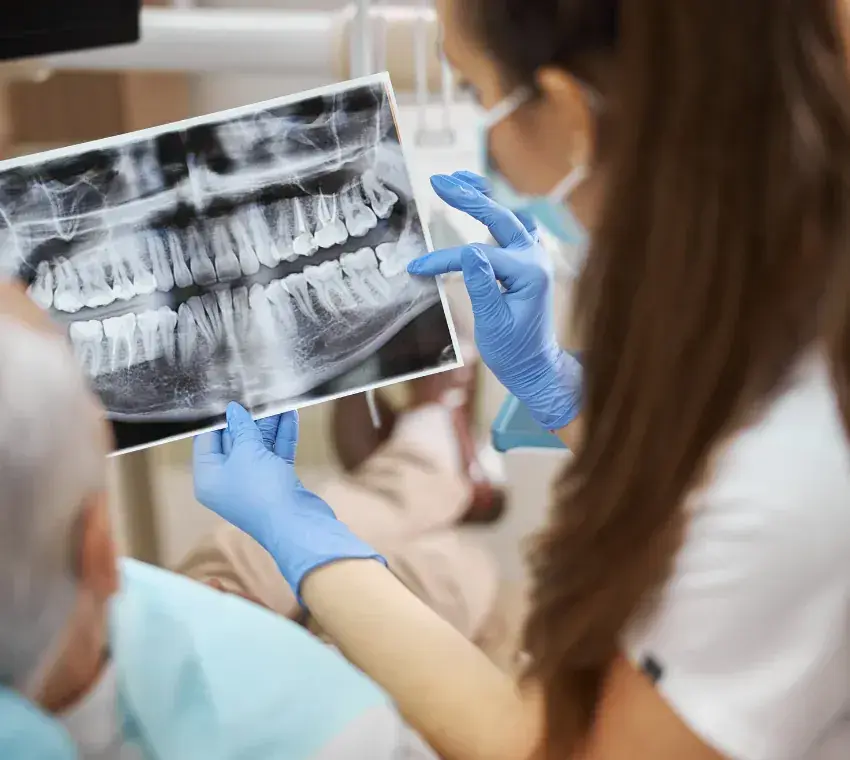 Dentist reviewing a dental X-ray while planning implant treatment